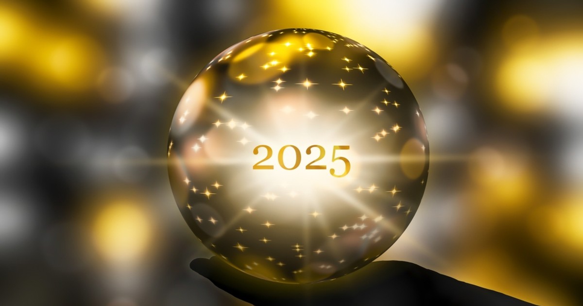 Horoscopul 2025 - Imagine cu o mână de femeie care ţine un glob de cristal pe care este inscripţionat 2025.