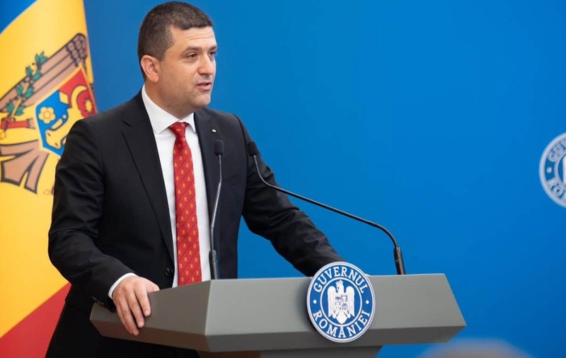 Ministrul interimar al Apărării, Radu Miruță, în timpul unei conferințe de presă la Guvernul României. Poartă un costum negru, o cămașă labă și o cravată roșie