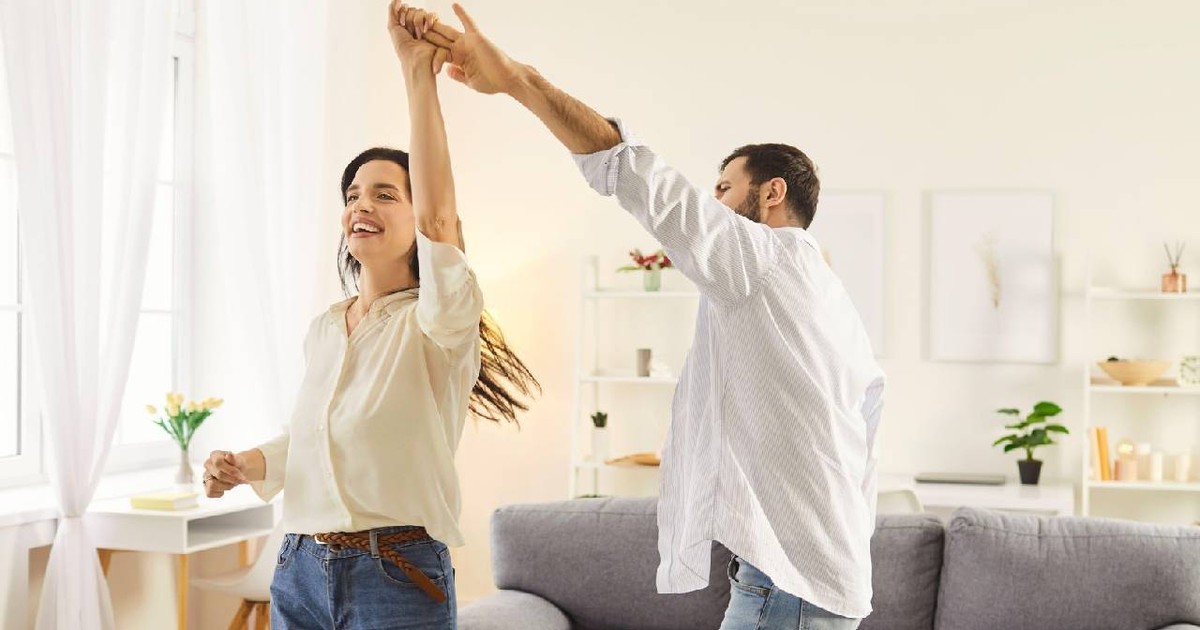Un cuplu fericit dansează prin casă cu cei doi oameni perfect relaxați