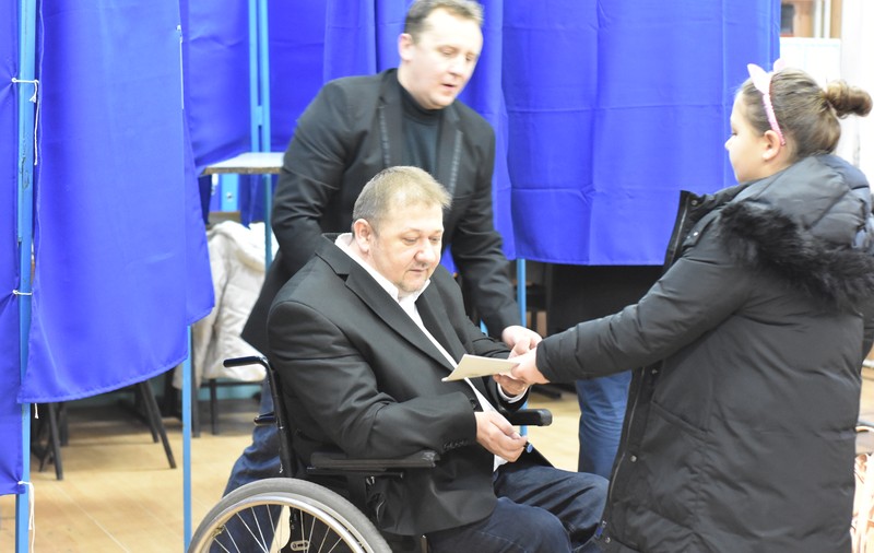 Alegeri parlamentare 2016. Primul candidat cu dizabilităţi din România a votat. Ionuţ Narcis Chisăliţă, în scaunul cu rotile la secția de votare