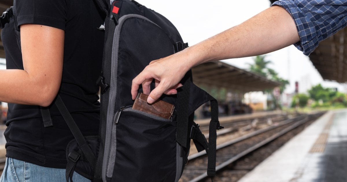 Un bărbat care fură un portofel din ghiozdanul unei femei