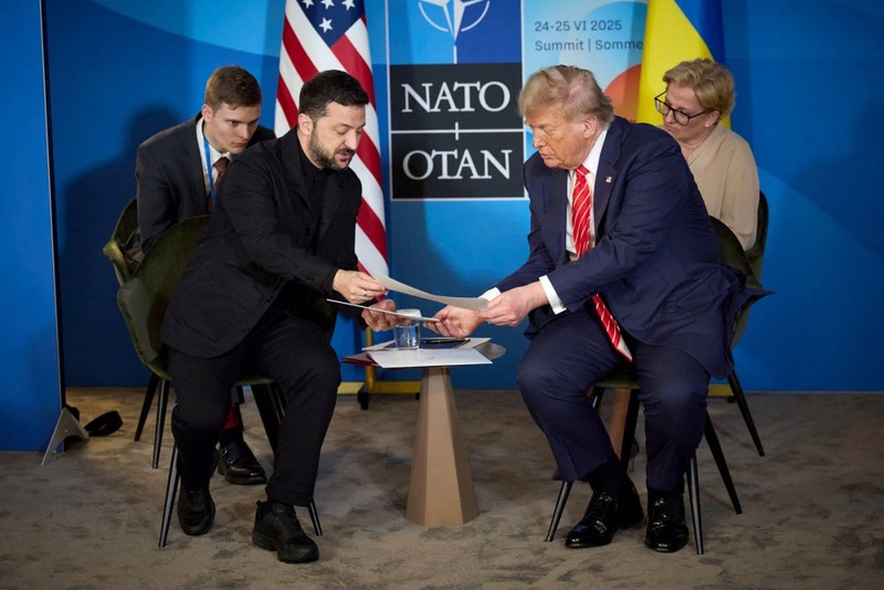 Volodimir Zelenski îi prezintă niște documente lui Donald Trump, în timpul întâlnirii în marja summitului NATO de la Haga. Foto: Profimedia