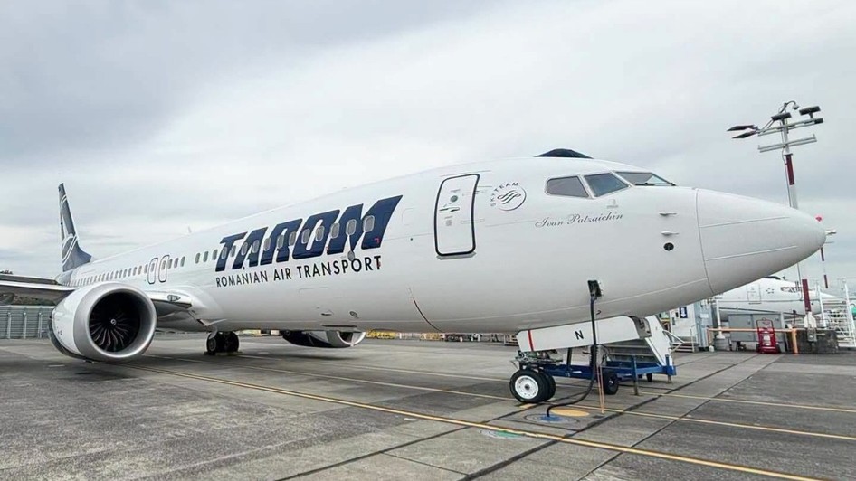 O aeronavă albă TAROM (cu numele de botez „Ivan Patzaichin” inscripționat în partea din față) staționată pe pista unui aeroport.