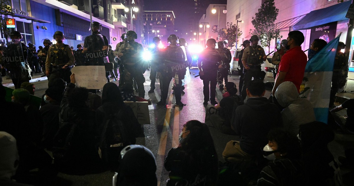 Protestatarii stau în stradă în fața unor polițiști, în timpul unui protest legat de imigrație în cartierul Little Tokyo din centrul orașului Los Angeles, pe 9 iunie 2025.