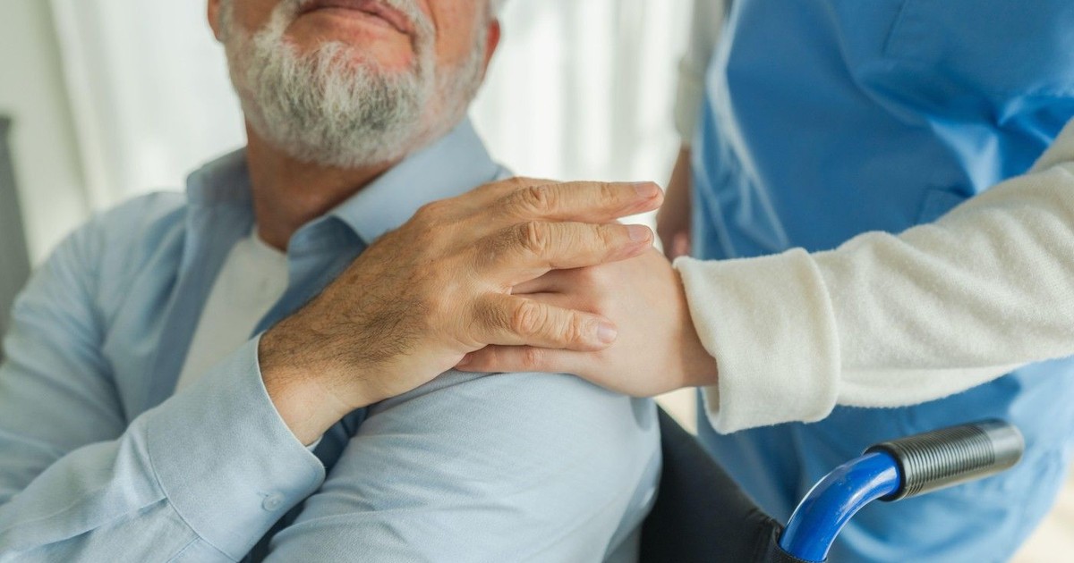 Asistentă medicală care ajută un bătrân în scaun cu rotile. Imagine cu caracter ilustrativ. Foto: Profimedia