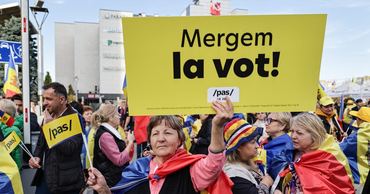Protest pro PAS în Republica Moldova (1). O femeie in varsta tine in mana o pancarta galbena pe care se poate citi: Mergem la vot