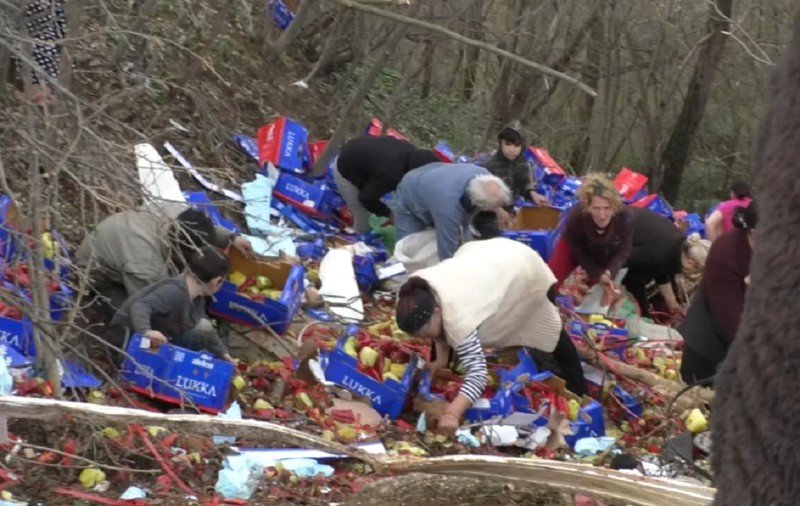 Zeci de oameni strâng de trei zile ardeii dintr-un TIR răsturnat într-o râpă, la Stârmina, în Mehedinți: „N-are ce mânca acasă” | VIDEO