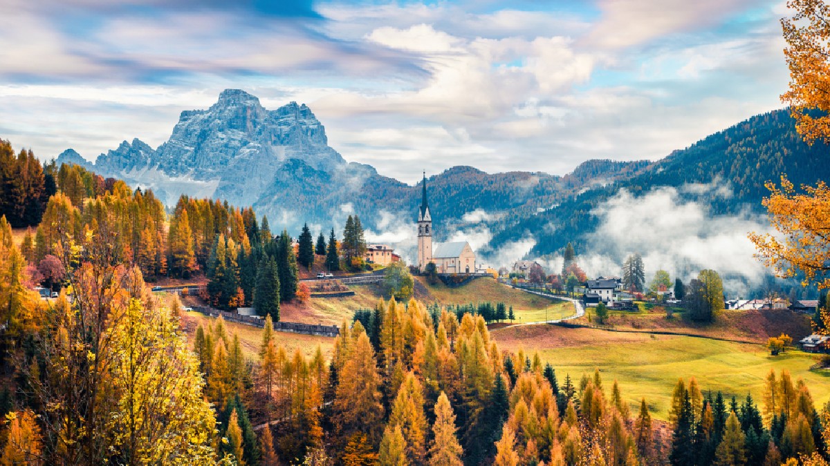 Vedere încețoșată de toamnă a bisericii Parrocchia Di Selva Cadore. Marea scenă de dimineață a Alpilor Dolomiți, Cortina d'Ampezzo, sudul Alpilor în regiunea Veneto din nordul Italiei, Europa.