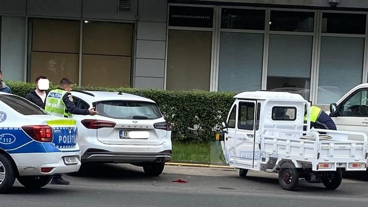 Un triciclu este parcat lângă o mașină albă, în timp ce un polițist care a coborât dintr-o autospecială vorbește cu un bărbat, iar un altul verifică triciclul, 6 octombrie 2025