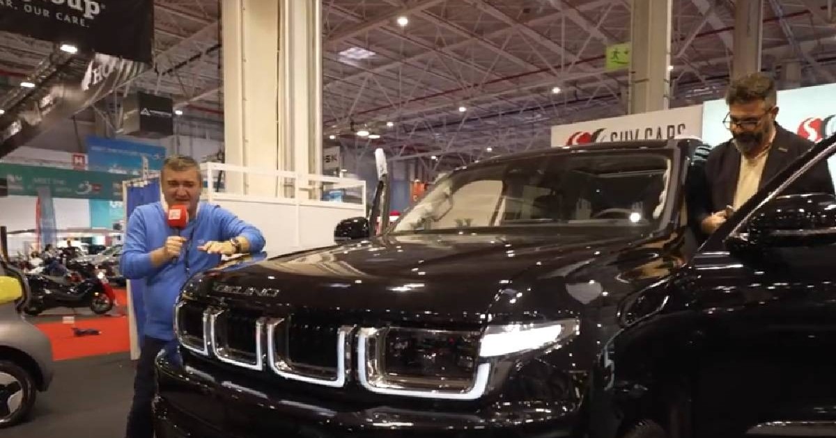 Jurnalistul Dorin Chioțea, lângă un SUV marca BAIC, o marcă chinezească de mașini, prezentă la Salonul Auto București