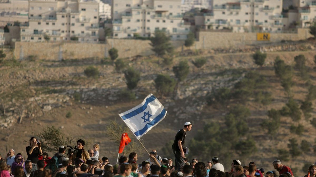 Coloniști israelieni dansează și cântă în timp ce ajung pe dealurile din noua zonă de colonizare E1, la 9 decembrie 2007, în apropierea așezării israeliene Maale Adumim din Cisiordania