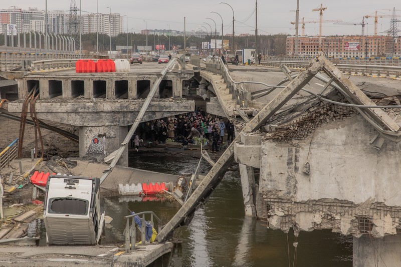 Locuitorii din zona Irpin sau adunat sub pod pentru o ceremonie comemorativa, 24 februarie 2024. Foto: AFP