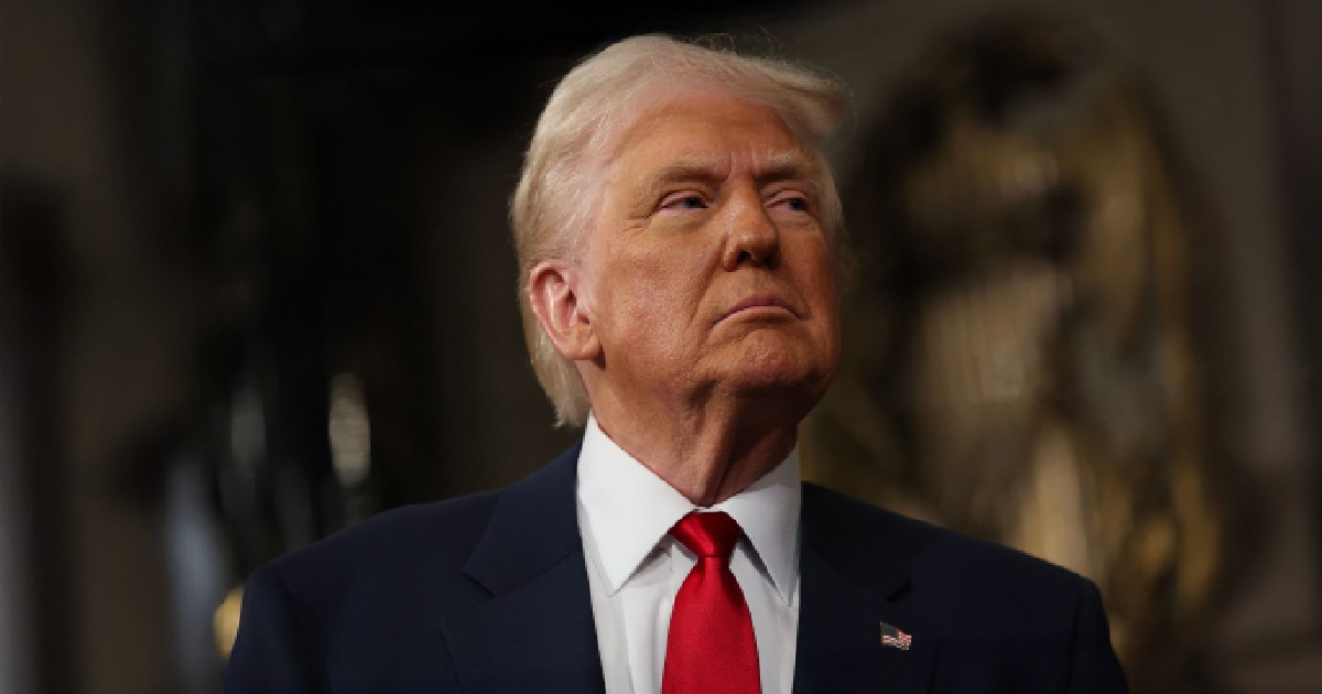 Imaginea este un portret, de la piept în sus, al lui Donald Trump. El este îmbrăcat într-un costum de culoare închisă, cu o cămașă albă și o cravată roșie. Expresia feței sale este serioasă, iar privirea este îndreptată în sus și spre dreapta. Fundalul este întunecat și estompat, ceea ce focalizează atenția asupra subiectului.