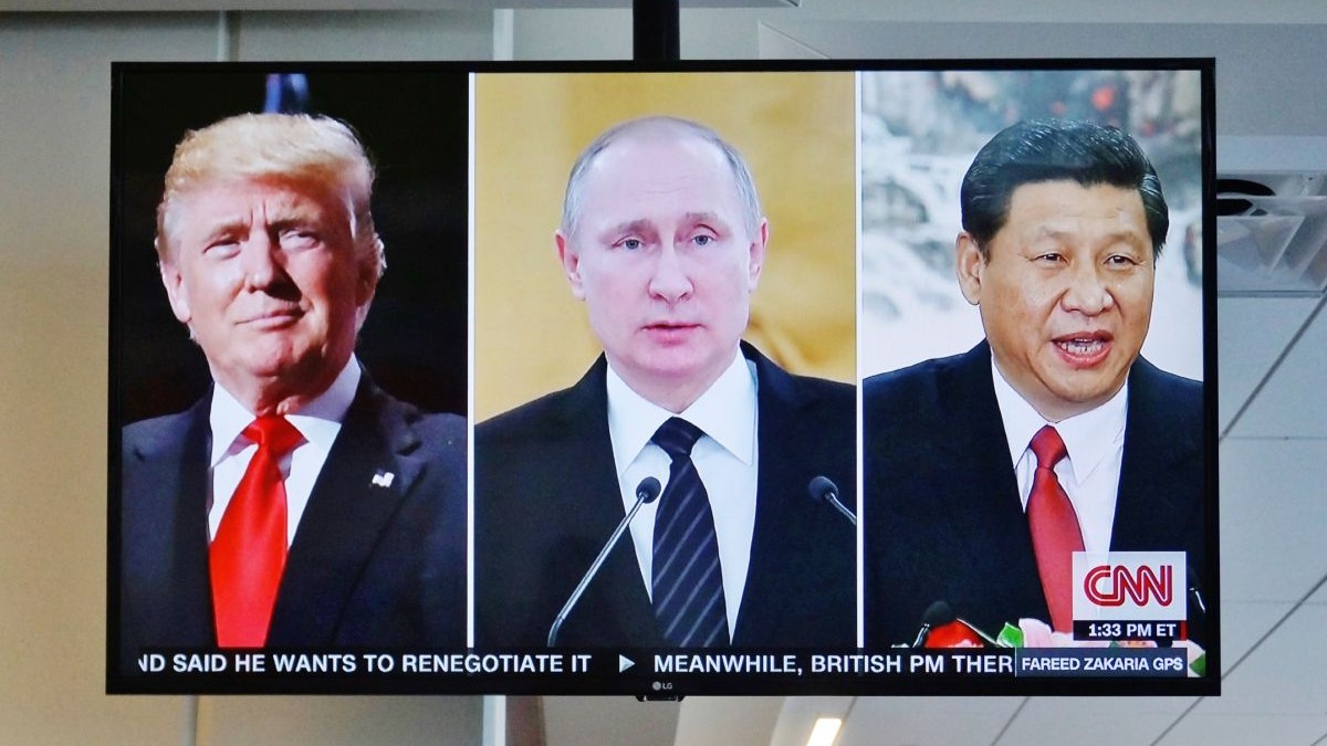Un televizor pe CNN în care apar trei ferestre cu Donald Trump, în stânga, Vladimir Putin în centru, și Xi Jinping în dreapta