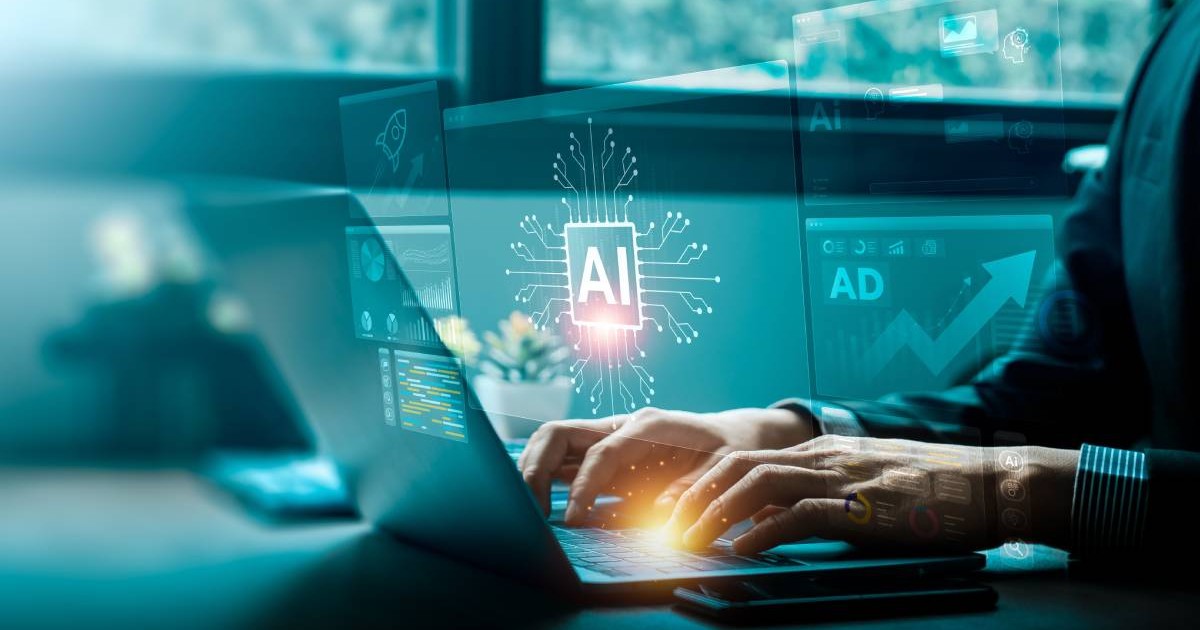 Cadru strans cu mainile unui barbat care lucreaza la un laptop, la dezvoltarea tehnologiilor de inteligență artificială, cu o interfață futuristă ce afișează pictograme de inteligență artificială
