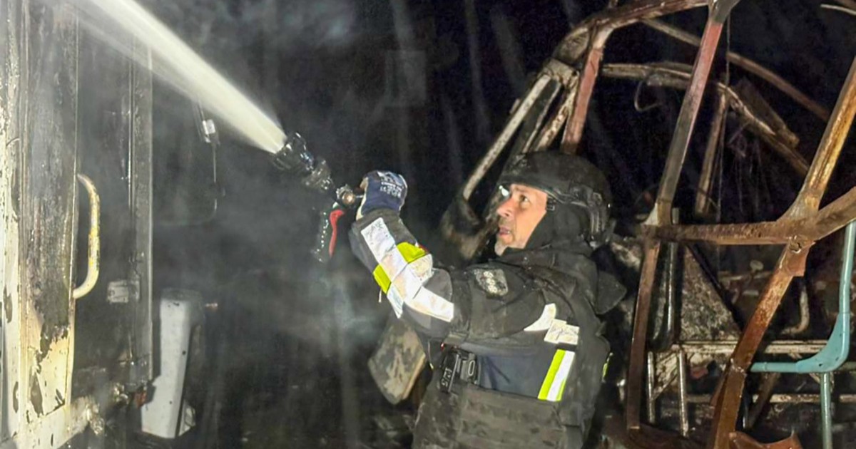 Un pompier ucrainean care încearcă să stingă un incendiu într-o casă din Ucraina, bombardată de Rusia