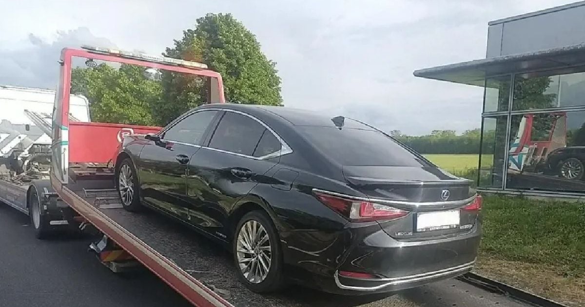 O mașină neagră berlină marca Lexus pe o platformă de tractare