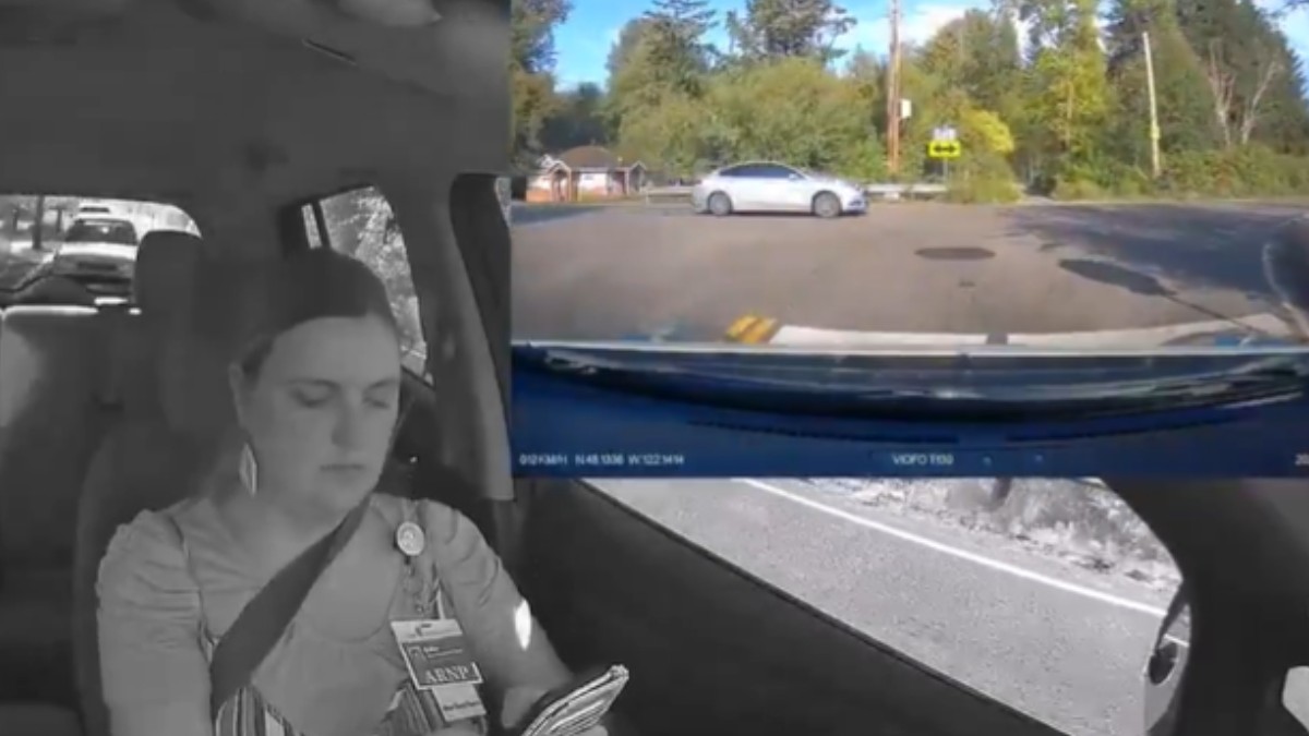 O femeie la volan, surprinsă de o cameră din mașină în timp ce tastează pe telefon.