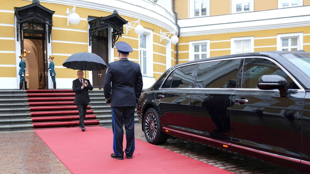 Vladimir Putin, cu o umbrelă în mână, iese de la Kremlin și se îndreaptă spre limuzina sa Aurus Senat Foto: Profimedia