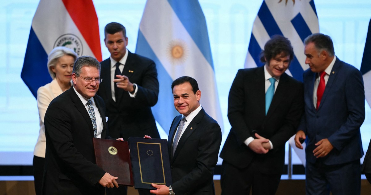 Comisarul european pentru comerț și securitate economică, Maros Sefcovic (stânga), și ministrul de externe al Paraguayului, Ruben Ramirez Lezcano, pozează pentru fotografii după semnarea documentelor în cadrul ceremoniei de semnare a acordului comercial între Uniunea Europeană și Mercosur, la Gran Teatro Jose Asuncion Flores al Băncii Centrale a Paraguayului din Asuncion, pe 17 ianuarie 2026. In plan se vede Javier Milei, presedintele Argentinei