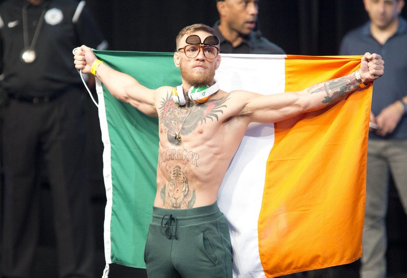 epa06163500 UFC champion Conor McGregor arrives for to the weigh-in ceremony holding an Irish flag at the T-Mobile arena in Las Vegas, Nevada, US, 25 August 2017. Conor McGregor will face off with Floyd Mayweather at the T-Mobile arena in Las Vegas on 26 August. EPA-EFE/ARMANDO ARORIZO