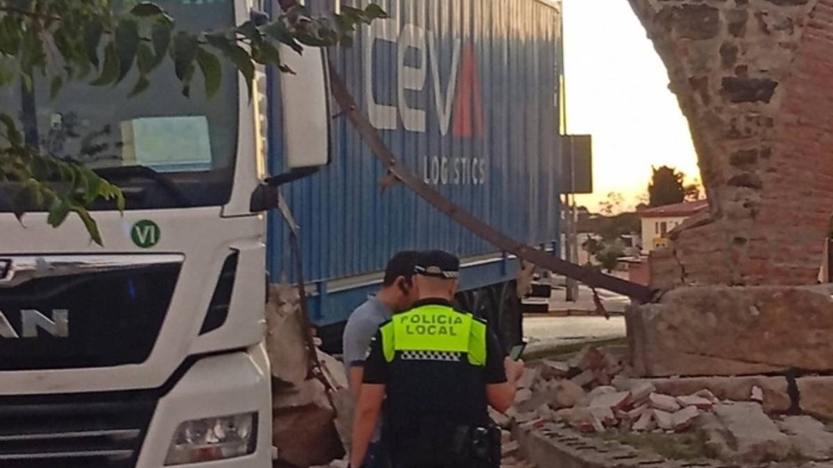 Polițiștii spanioli și șoferul român de TIR la locul accidentului, bucăți din apeduct se văd căzute în jurul autocamionului.