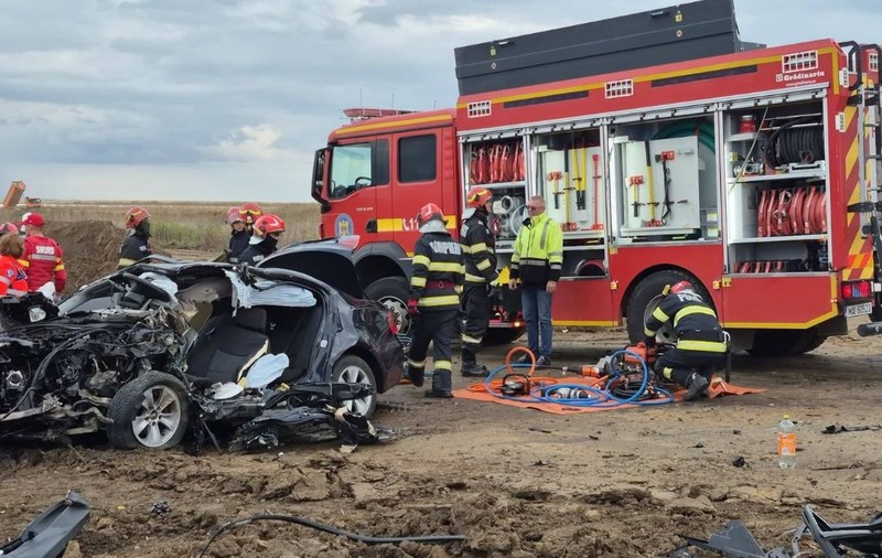 accident rutier între Pașcani și Brătești, 23 sept 2026 - locul unui accident grav pe un teren de pământ, unde un autoturism complet distrus și zdrobit se află lângă o autospecială mare de pompier