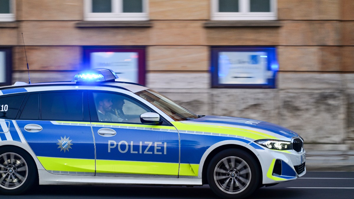 O mașină de poliție din Germania, în mișcare. Locurile din față sunt ocupate de doi bărbați.