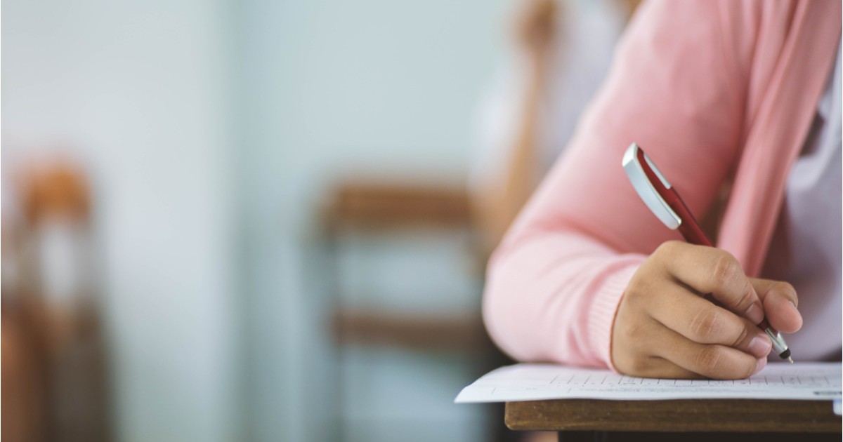 O elevă în timpul unui examen, cu un pix în mână