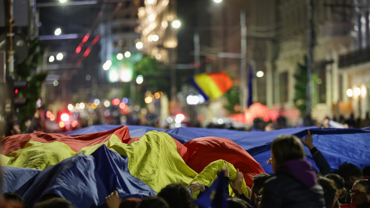 un drapel imens purtat de mai multi oameni pe strazile bucurestiului