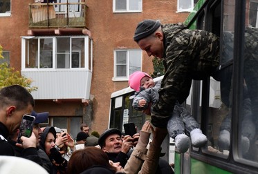Un bebeluș primește o îmbrățișare de la tatăl care pleacă la război. Chkalovsky, Ekaterinburg, 27 septembrie 2022. Foto: EPA