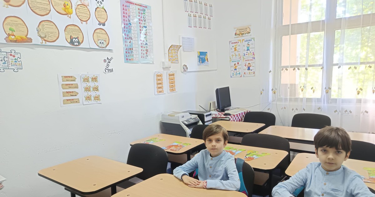 Elevi în bănci într-o clasă goală