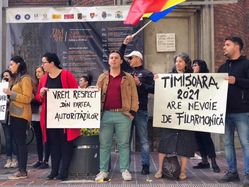 Protest cu tobe și trompete în fața Filarmonicii Banatul din Timișoara. Reclamă modul cum sunt tratați de către conducere