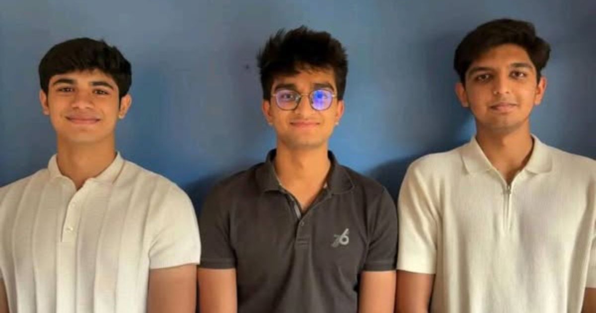 trei băieti din India stau la poza la un perete albastru - Dhruv Chaudhary, Mithran Ladhania și Mridul Jain au lucrat împreună pentru a construi un frigider alimentat cu sare.