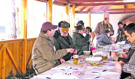 Omul de afaceri Ion Tiriac discuta cu invitatii sai, in timpul mesei organizate inainte de a doua partida a vanatorii de mistreti de la Balc, judetul Bihor, sambata, 17 ianuarie 2009.