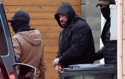 Karlos Vemola, în momentul arestării, în hanorac și cu gluga trasă pe cap. Foto: Profimedia