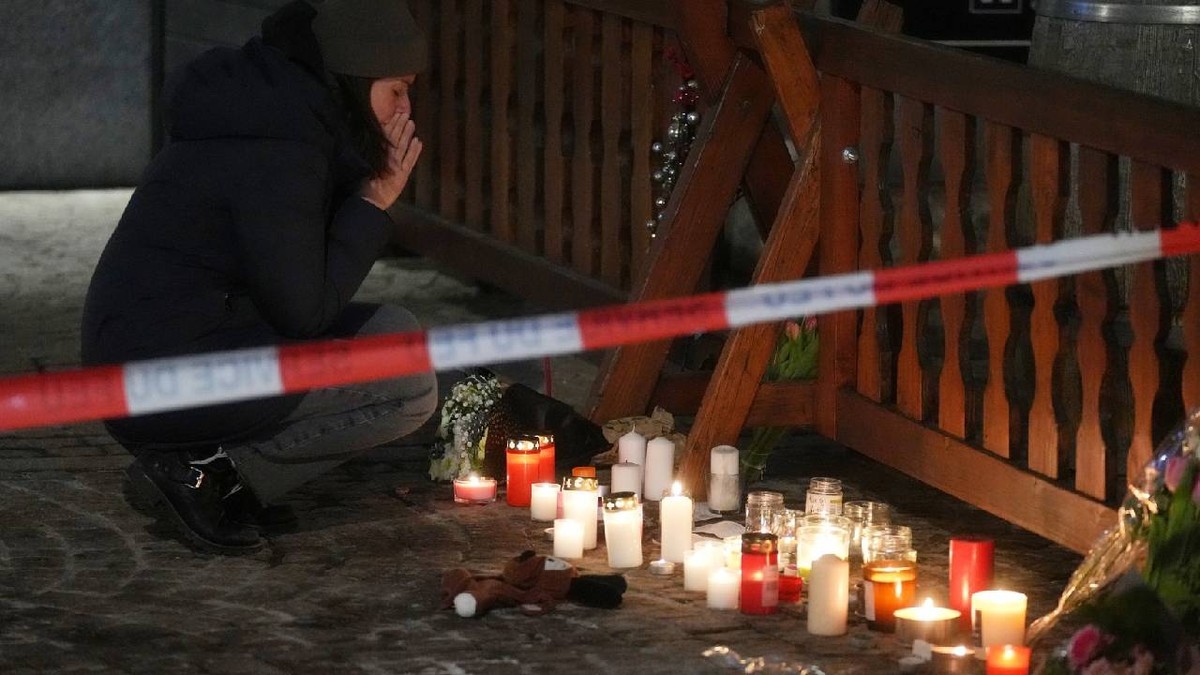 Oamenii jelesc lângă lumânări și flori în apropierea barului Le Constellation, unde un incendiu devastator a lăsat morți și răniți în timpul sărbătorilor de Anul Nou din Crans-Montana.
