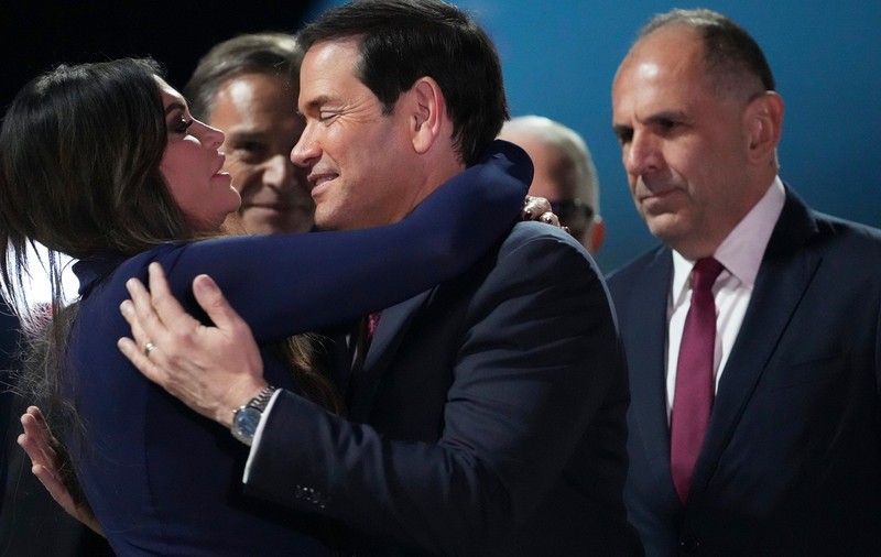 Kimberly Guilfoyle îl îmbrățizează pe șeful său, Marco Rubio, în prezența ministrului grec de externe  George Gerapetritis Sursa foto: Profimedia