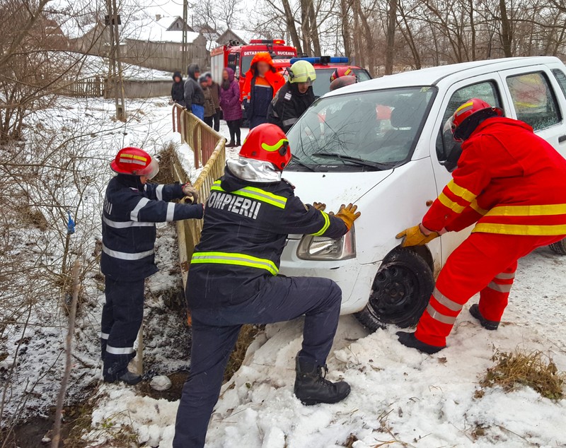 O femeie blocată într-o mașină care rămăsese suspendată pe un pod din județul Suceava a fost salvată de pompierii militari