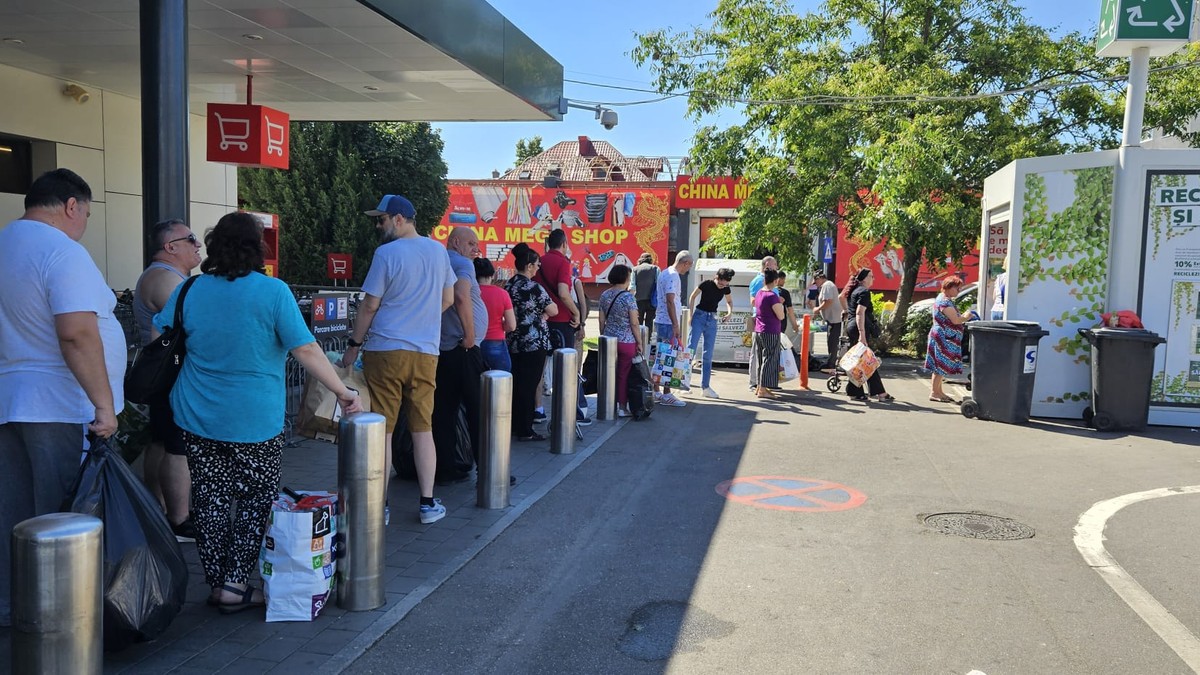 Oameni care steapta la un automat de reciclare în incinta unui magazin Kaufland din București - 16 mai 2024.