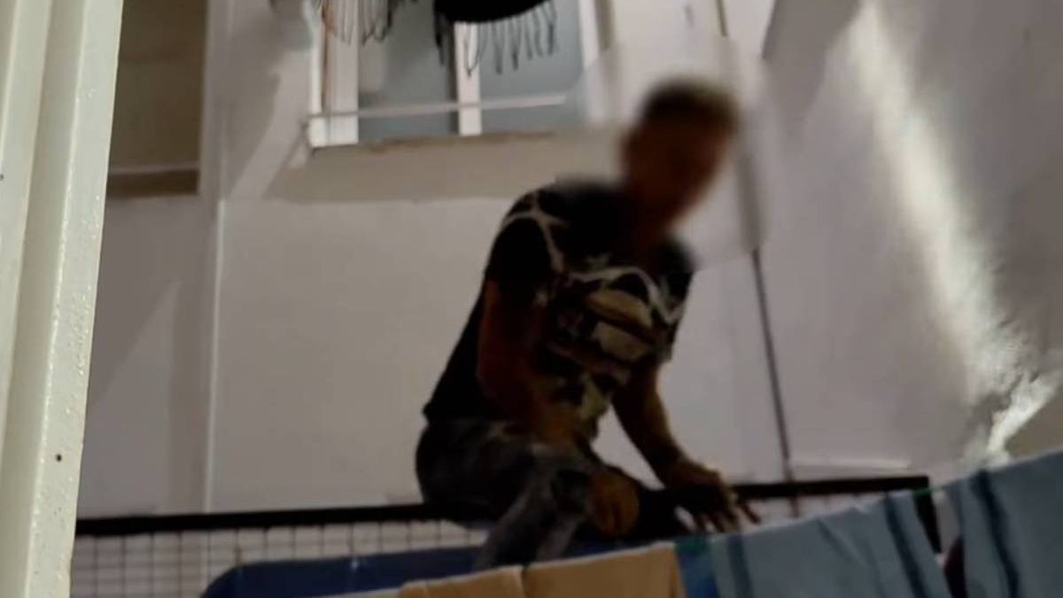 Un barbat cu fata blurat, hoț recidivist roman, surprins in timp ce voia sa fuga de politie pe fereastră.