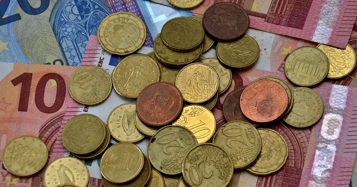 Monede metalice și bancnote de euro aruncate unele peste altele, în dezordine