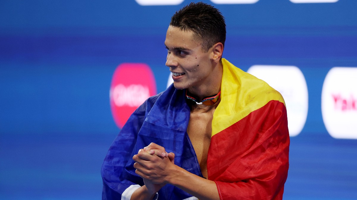 David Popovici care poartă pe spate steagul României