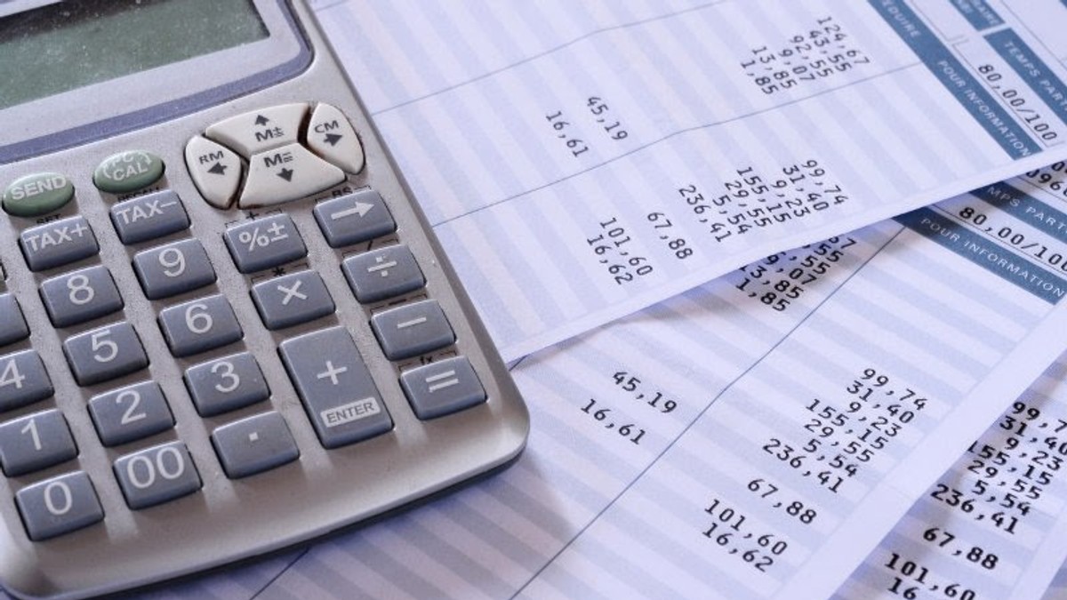 Studiu Adecco: 45% dintre companii vor majora salariile angajaților pentru a compensa trecerea contribuțiilor, iar 37% așteaptă răspuns de la sediile centrale ale multinaționalelor. Calculator cu foi pe o masă