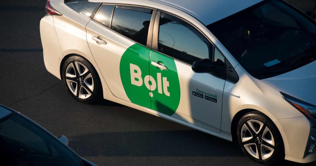 O mașină albă pe care este atașat logo-ul Bolt