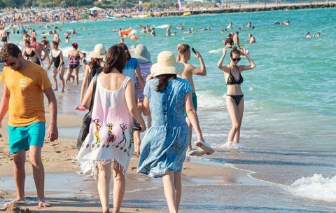 Plajă din Costinești cu mulți oameni care se bronzeză, înoată sau se plimbă de-a lungul țărmului pe nisipul fierbinte, 7 iulie 2024