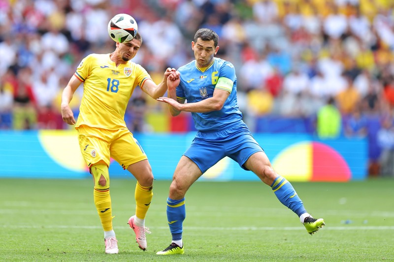 17 June 2024, Bavaria, Munich: Romania's Razvan Marin (L) and Ukraine's Taras Stepanenko battle for the ball during the UEFA Euro 2024 group E soccer match between Romania and Ukraine at the Munich Football Arena. Photo: Daniel Karmann/dpa