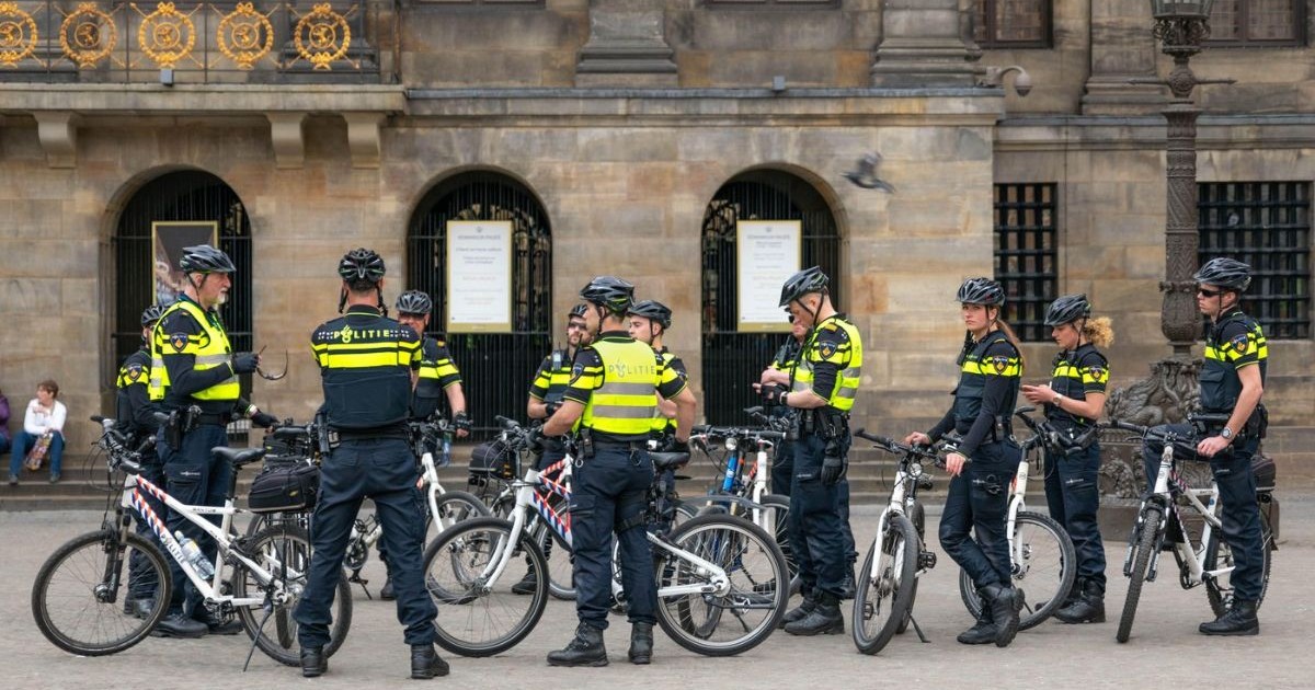 Polițiștii în uniformă, pe biciclete și cu căști, mențin ordinea.