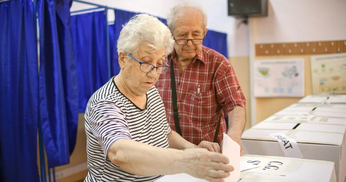 O femeie introduce buletinul in urna de vot
