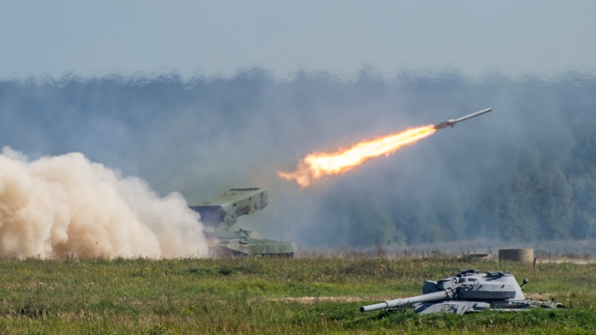 Momentul lansării unei rachete dintr-un sistem militar autopropulsat pe un câmp, lăsând în urmă o jerbă masivă de foc și fum alb dens.   